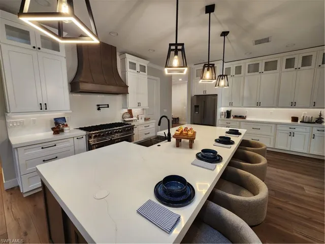 Kitchen with glass insert cabinets, dark wood finished floors, and a kitchen bar