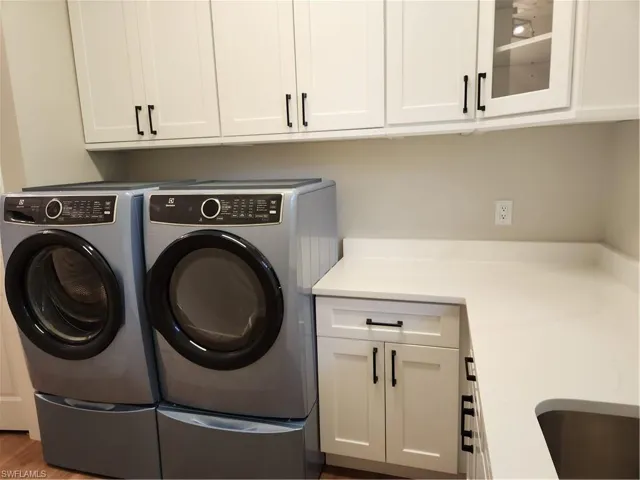Laundry area featuring washer and clothes dryer and cabinet space