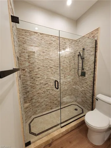 Bathroom with a stall shower and wood finished floors