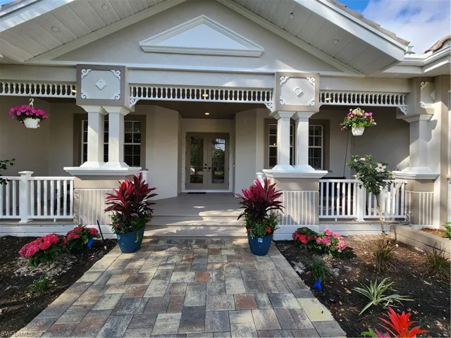 Doorway to property with french doors, covered porch, and stucco siding