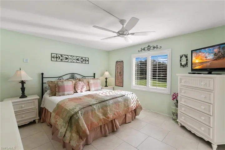Bedroom with light tile patterned floors and ceiling fan