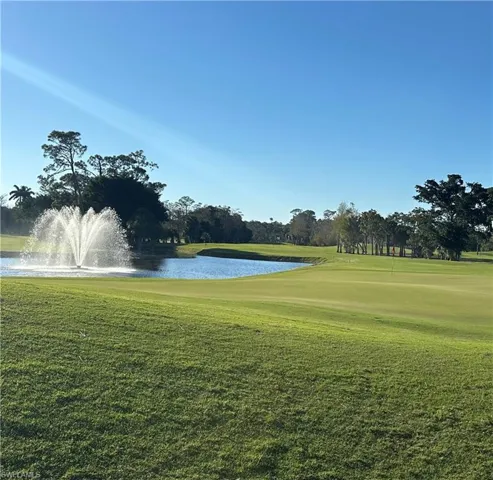 View of property's community featuring a water view, view of golf course, and a lawn
