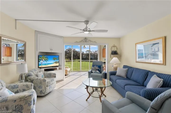 Living room with light tile patterned floors and ceiling fan
