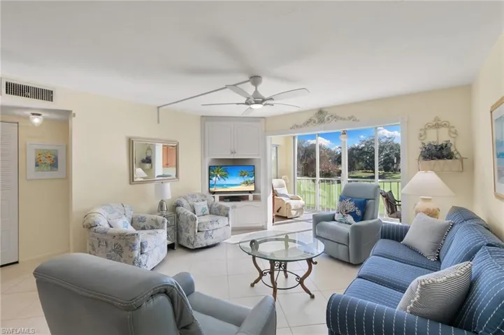 Living room featuring light tile patterned flooring and ceiling fan