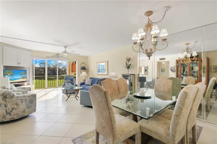 Dining area featuring light tile patterned flooring and ceiling fan with notable chandelier