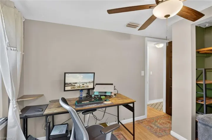 Office with light wood finished floors and ceiling fan