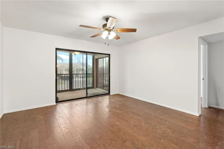 Unfurnished room featuring dark wood finished floors and a ceiling fan