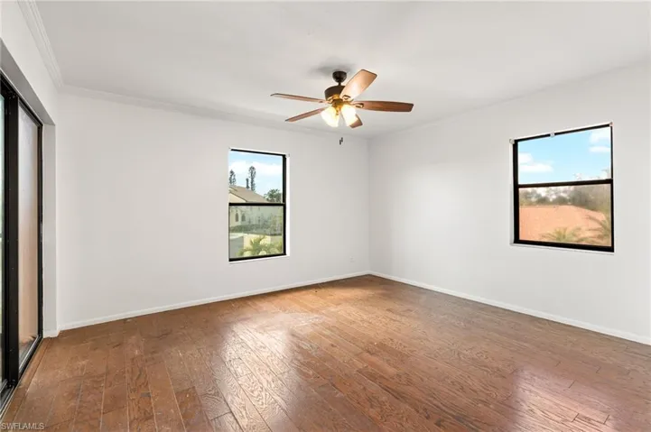 Empty room featuring ornamental molding, hardwood / wood-style floors, and a ceiling fan