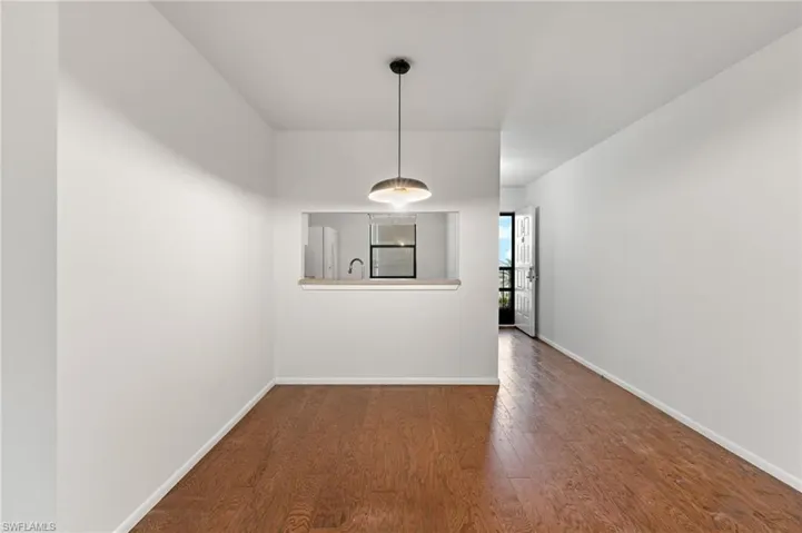 Unfurnished dining area with dark wood-type flooring