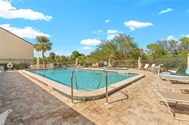 Community pool with a patio and a hot tub