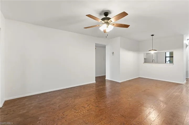 Unfurnished room with dark wood-style floors and ceiling fan