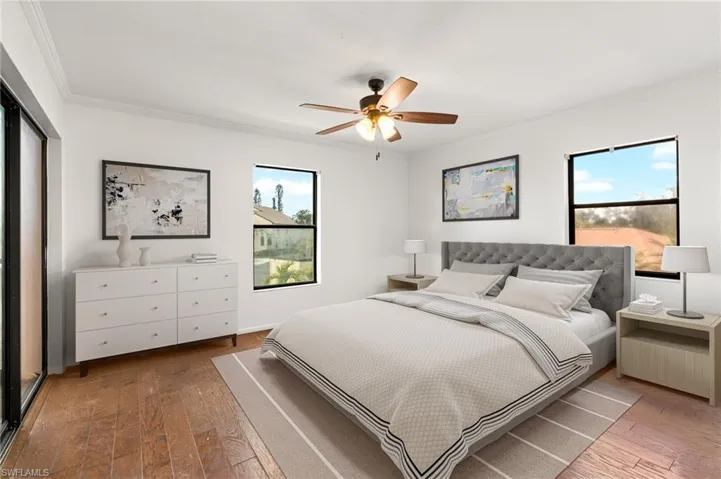 Bedroom with ornamental molding, wood-type flooring, and ceiling fan