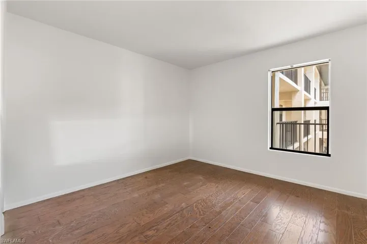 Empty room featuring baseboards and dark wood finished floors