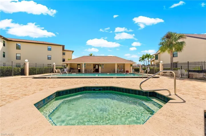Community pool with a patio area, a hot tub, and a residential view