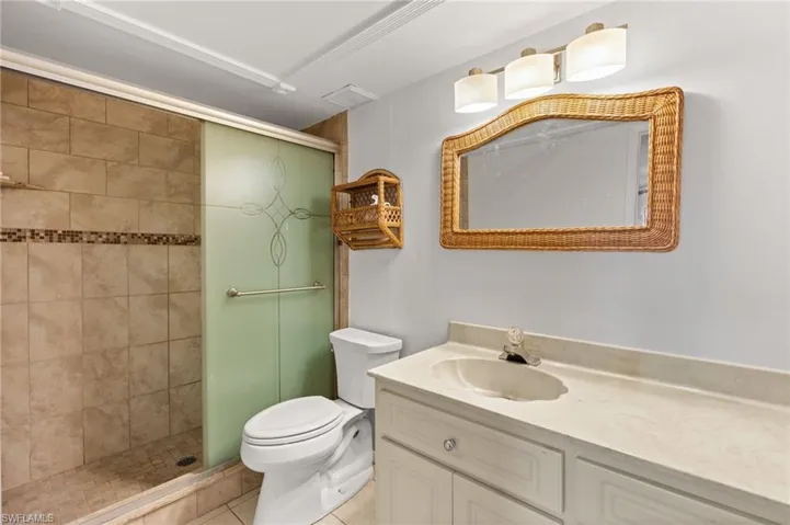 Bathroom featuring a shower stall, vanity, and light tile patterned floors