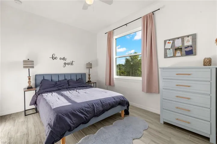 Bedroom featuring a ceiling fan, baseboards, and light wood-type flooring