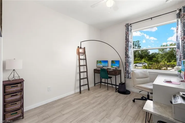 Office featuring light wood finished floors, baseboards, and a ceiling fan