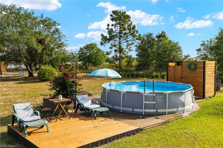 Pool featuring a wooden deck and a yard