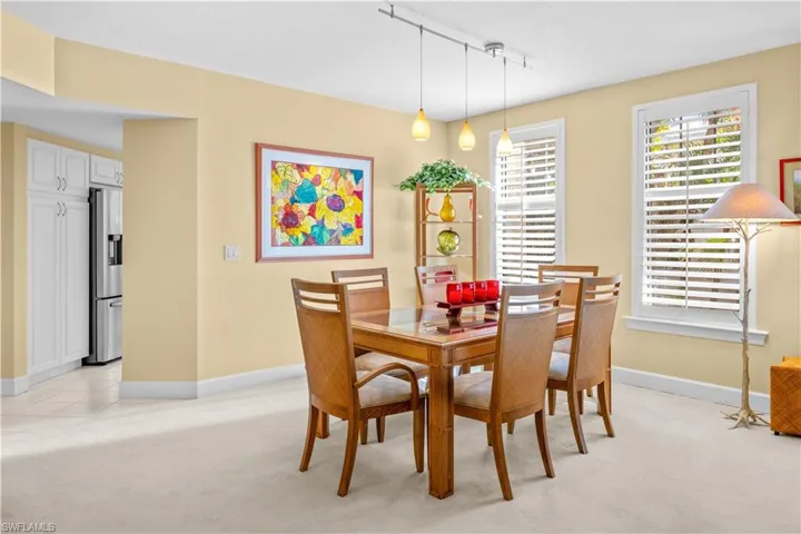 Dining area with light carpet and track lighting