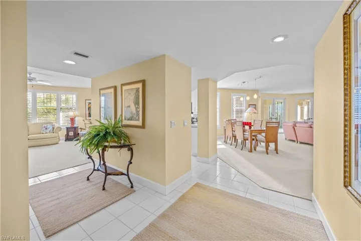 Corridor with light tile patterned floors, light colored carpet, and rail lighting