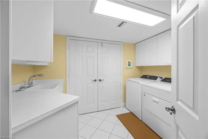 Laundry room featuring cabinet space, separate washer and dryer, and light tile patterned floors