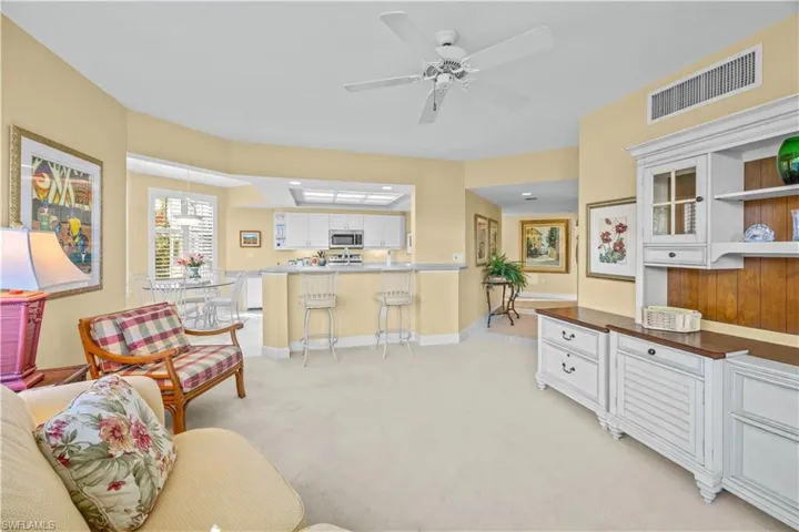 Living area featuring light carpet and a ceiling fan