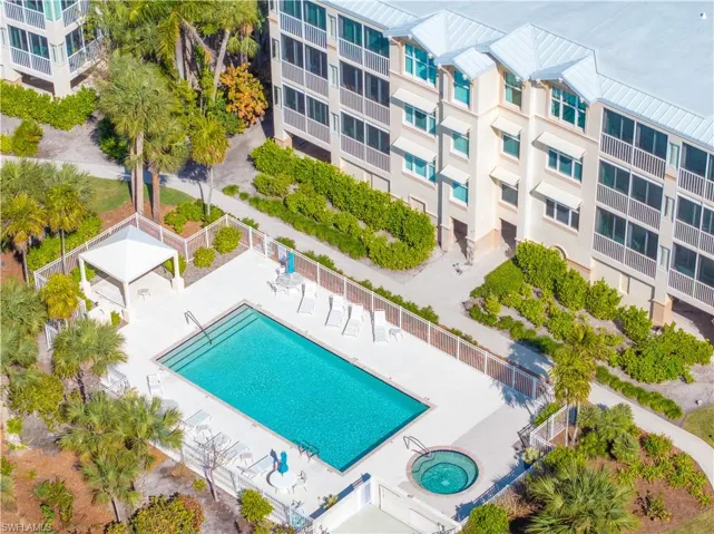 Community pool with a patio and a hot tub