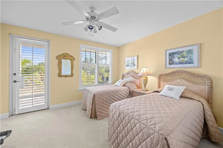 Carpeted bedroom with access to exterior and ceiling fan