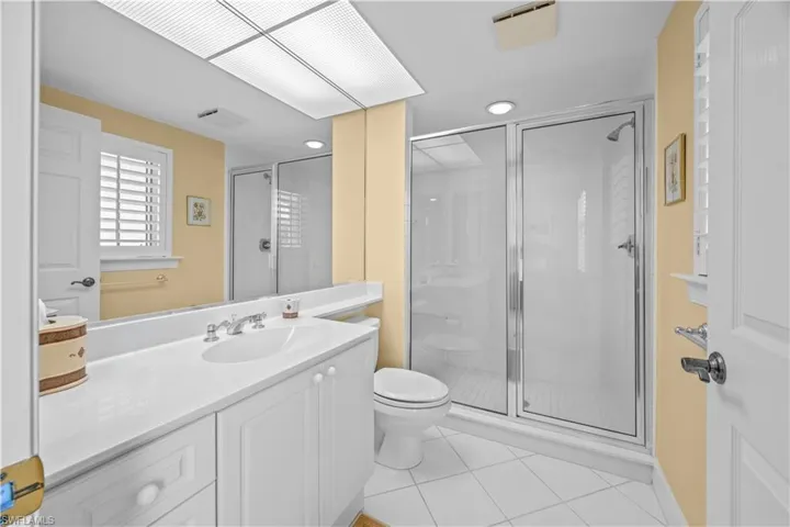 Full bathroom with a shower stall, vanity, light tile patterned floors, and recessed lighting