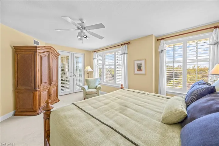 Bedroom featuring access to outside, light colored carpet, ceiling fan, a textured ceiling, and french doors