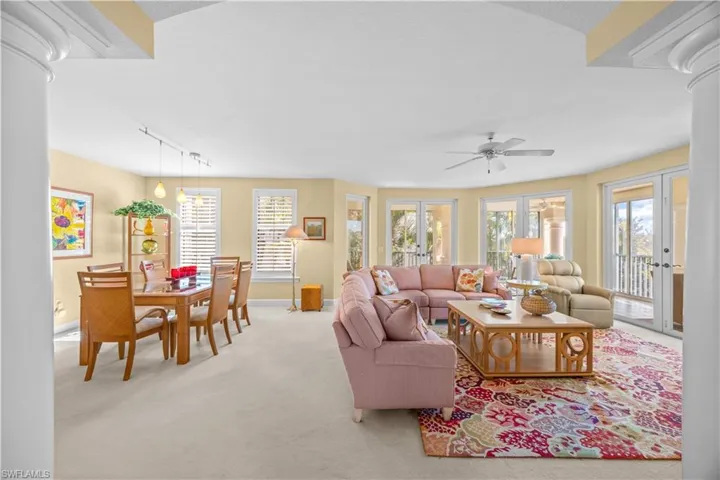 Living room with french doors, decorative columns, carpet, and track lighting