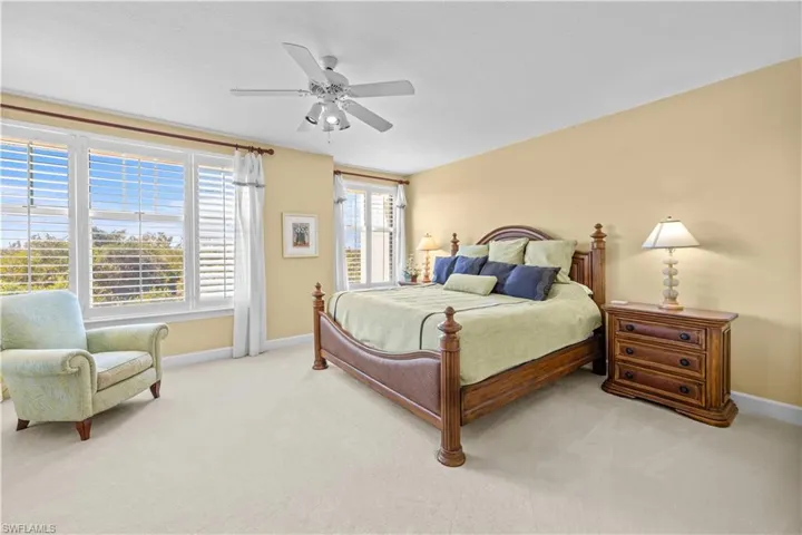 Bedroom with light colored carpet and ceiling fan