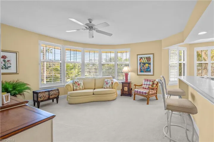 Living room featuring light colored carpet and a ceiling fan