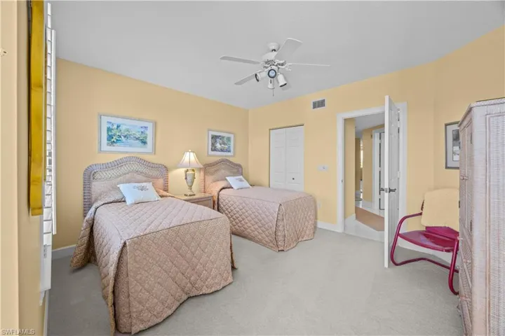 Carpeted bedroom with a closet and ceiling fan