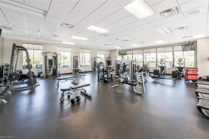 Workout area featuring a drop ceiling and healthy amount of natural light