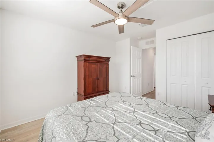 Bedroom with light wood-style flooring, a closet, and ceiling fan