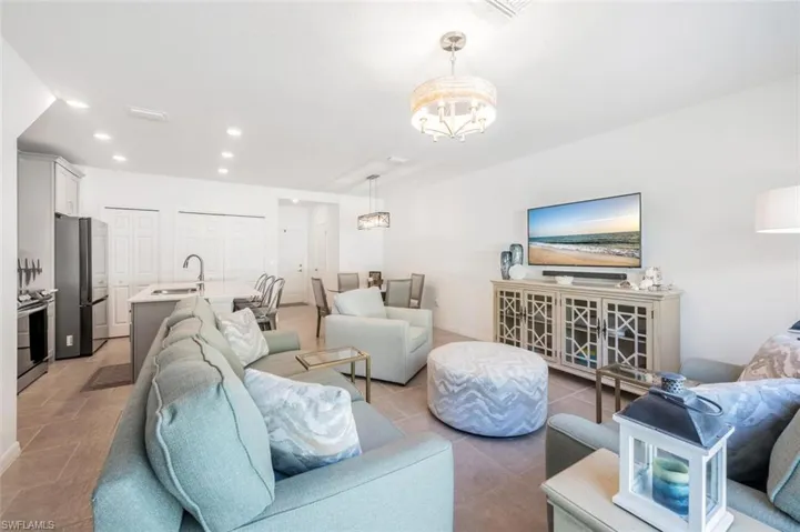 Living room with recessed lighting, a chandelier, and light tile patterned floors