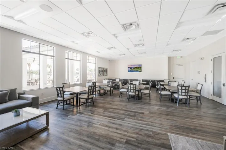Dining area featuring a drop ceiling and dark wood-style floors