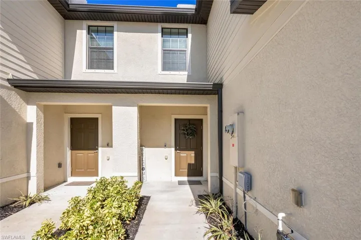 Property entrance featuring stucco siding and a porch