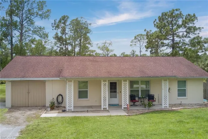 Ranch-style house with a front lawn, roof with shingles, and stucco siding
