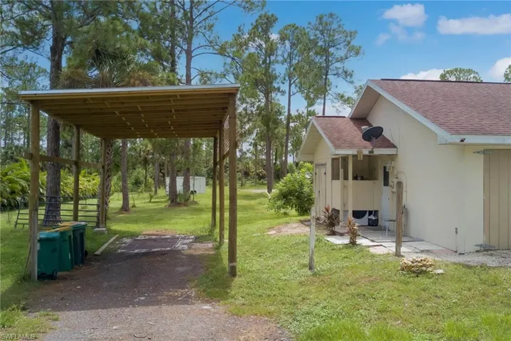 View of grassy yard with a patio area and driveway