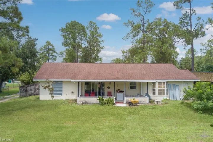 View of front facade with a shingled roof and stucco siding