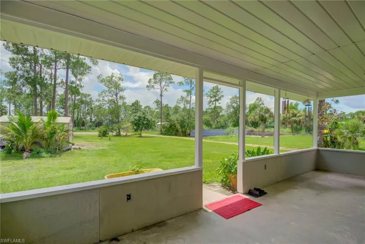 Unfurnished sunroom featuring view of wooded area