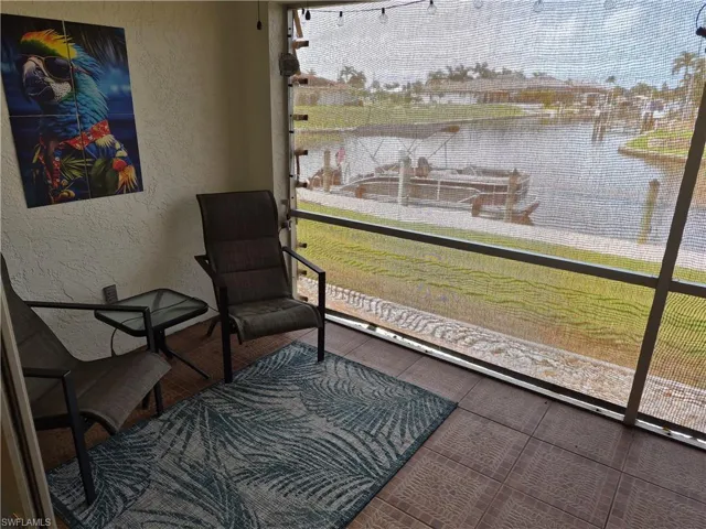 Screened patio with tiled flooring and a serene waterfront outlook