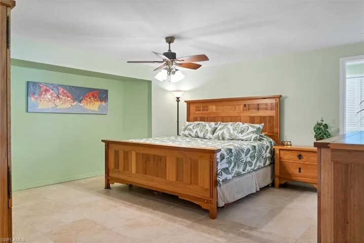 Tiled bedroom featuring ceiling fan