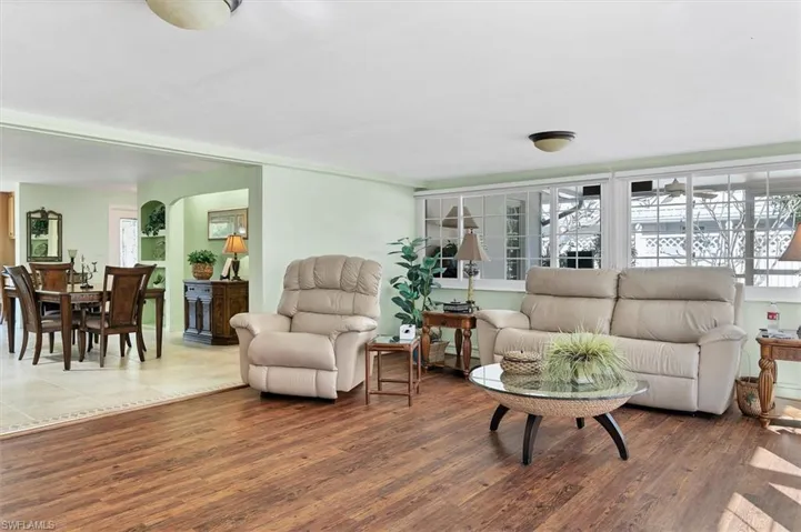 Living room with plenty of natural light and dark wood-type flooring