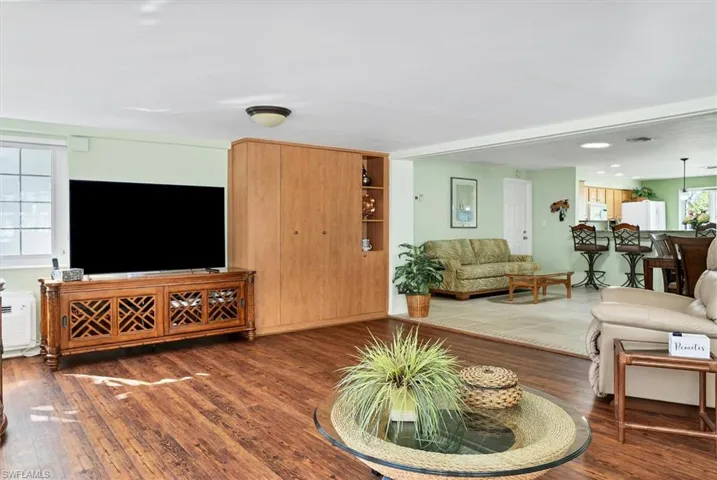 Living room with a wealth of natural light and dark hardwood / wood-style flooring