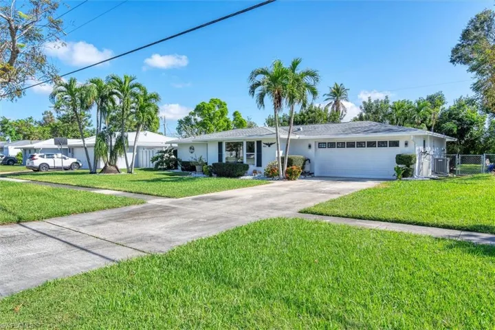 Ranch-style home featuring a front lawn and a garage