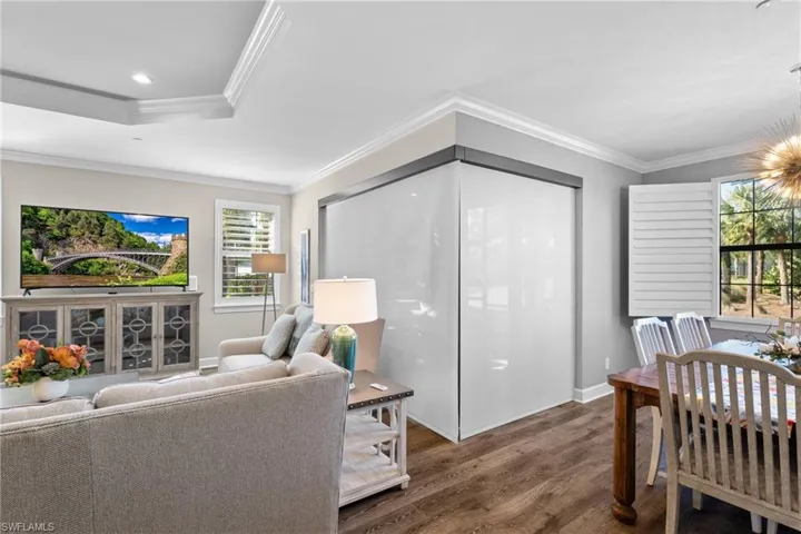 Living room featuring hardwood / wood-style floors and crown molding