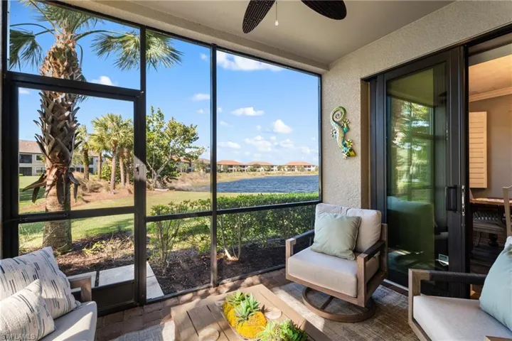 Sunroom / solarium with ceiling fan, a water view, and a wealth of natural light